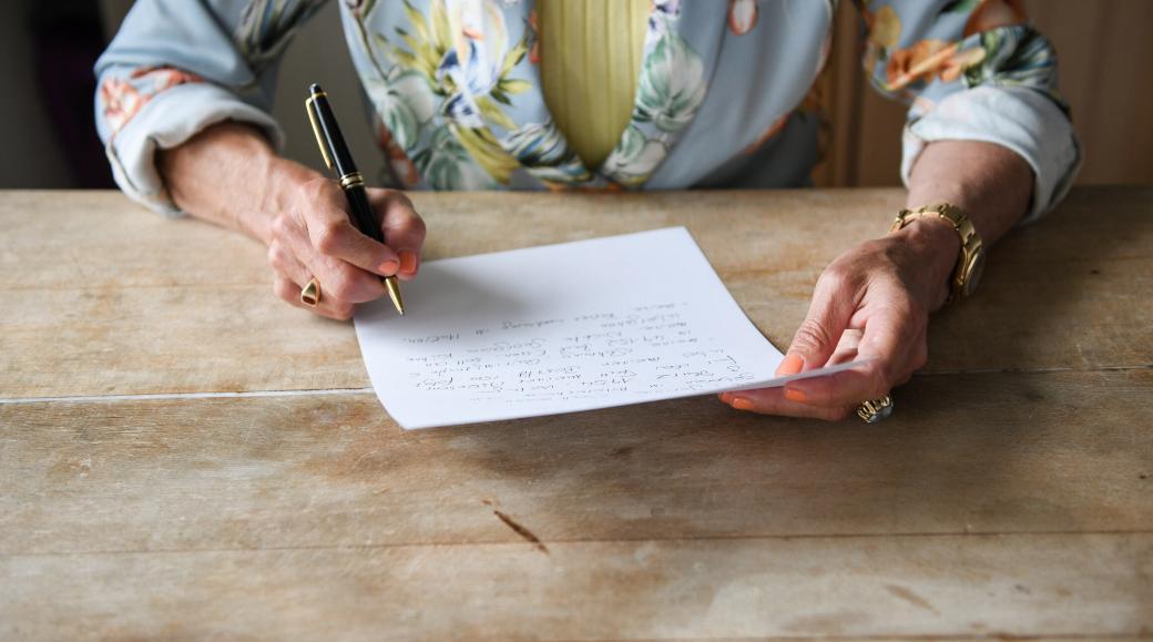 Eine Frau beim verfassen ihres handschriftlichen letzten Willens.