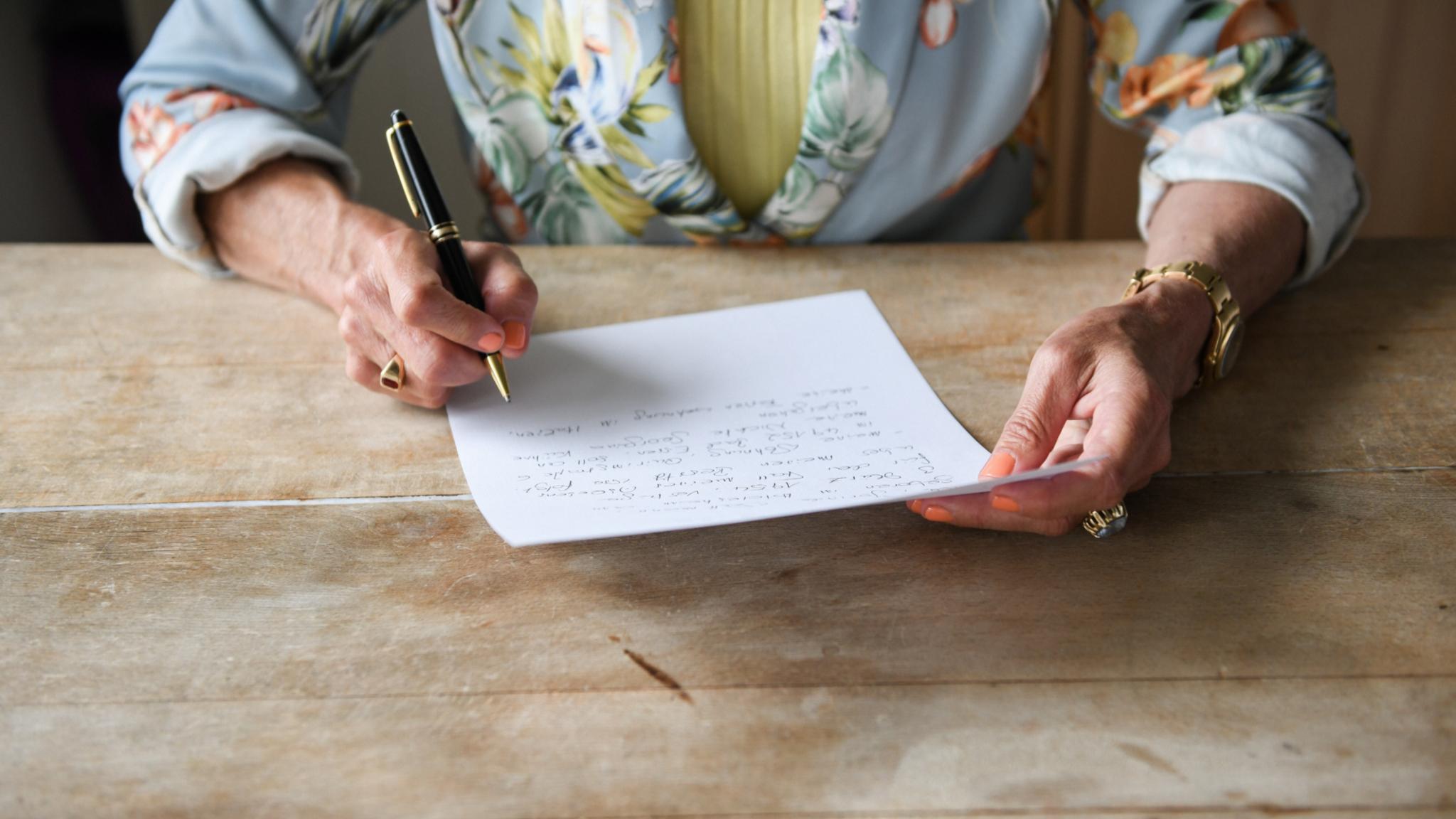 Eine Frau beim verfassen ihres handschriftlichen letzten Willens.