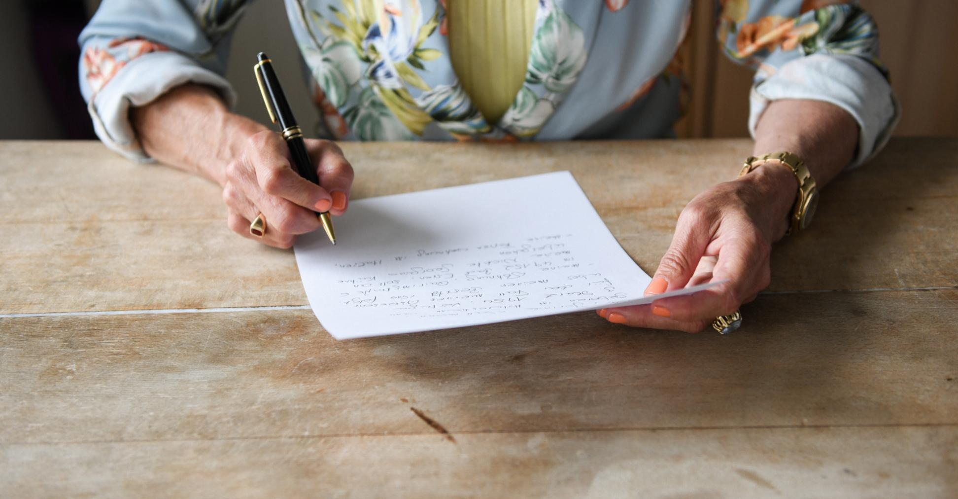 Eine Frau beim verfassen ihres handschriftlichen letzten Willens.
