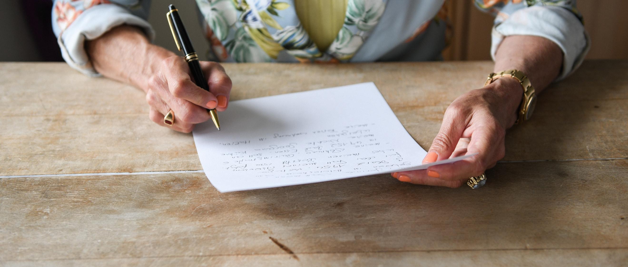 Eine Frau beim verfassen ihres handschriftlichen letzten Willens.