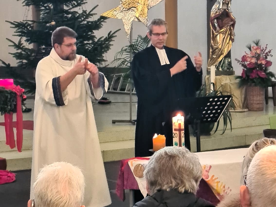 Daniel Beinhoff (links) und der evangelische Pfarrer Tilmann Raithelhuber feiern in Koblenz einen Gottesdienst mit Gebärdensprache.