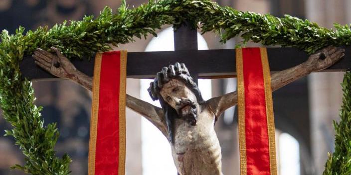 Jesus hängt am Kreuz, umrahmt von Palmzweigen