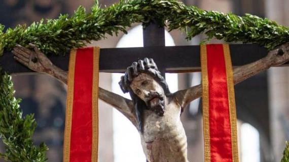 Jesus hängt am Kreuz, umrahmt von Palmzweigen