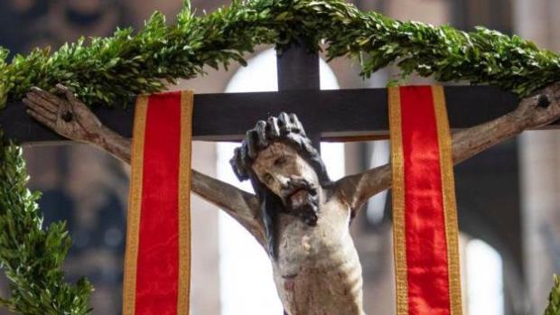 Jesus hängt am Kreuz, umrahmt von Palmzweigen