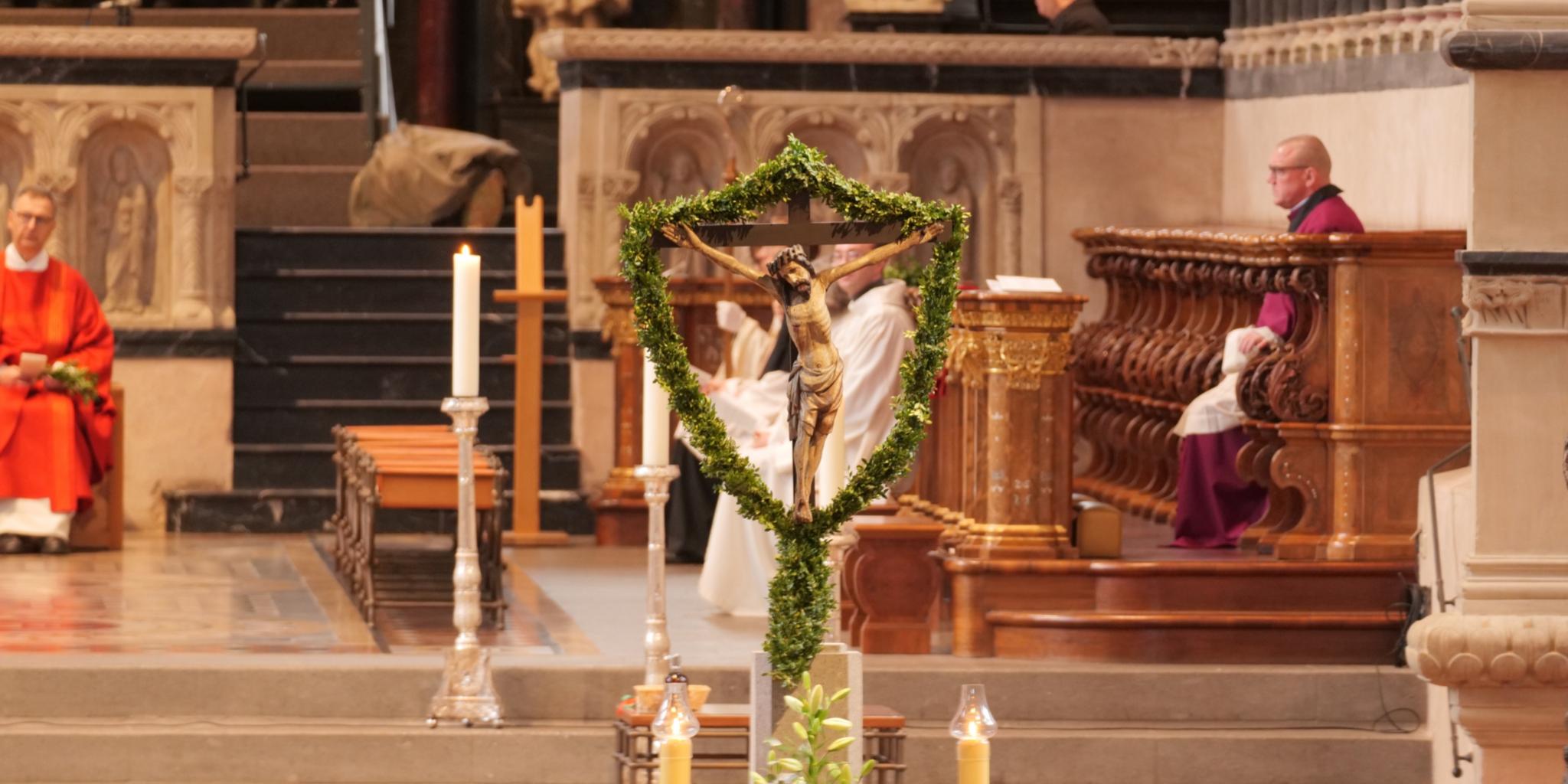 Das Kreuz mit Jesus ist umgeben von Palmzweigen