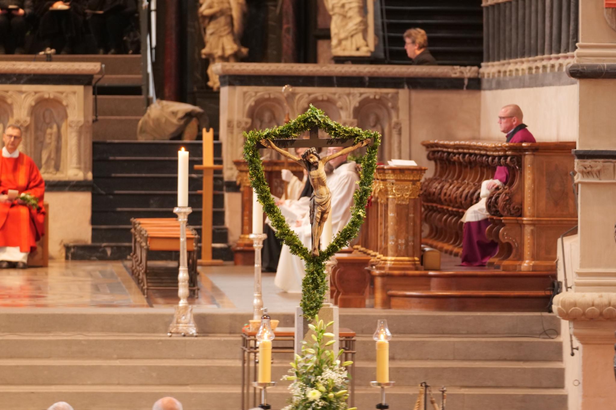 Das Kreuz mit Jesus ist umgeben von Palmzweigen