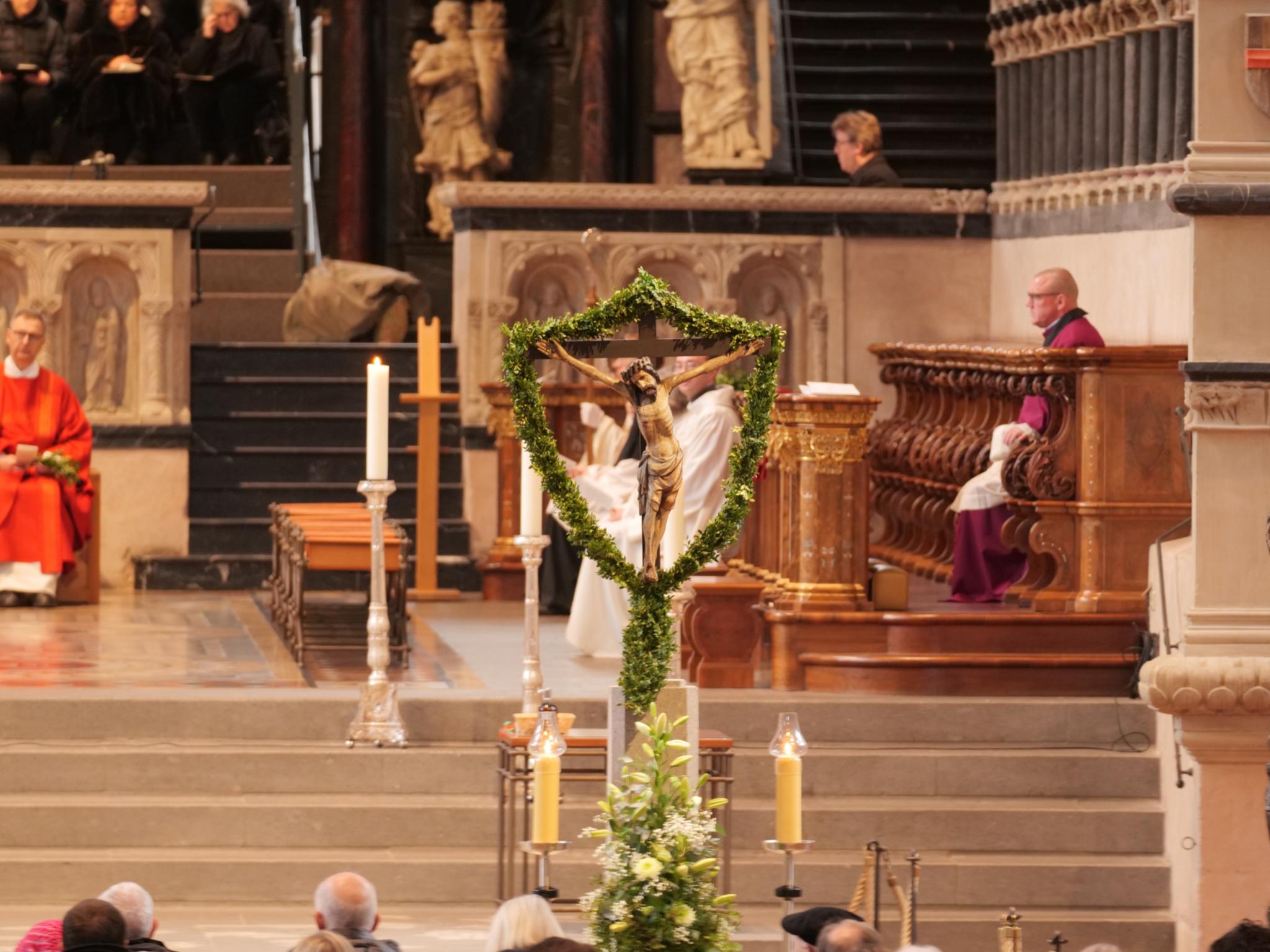 Das Kreuz mit Jesus ist umgeben von Palmzweigen