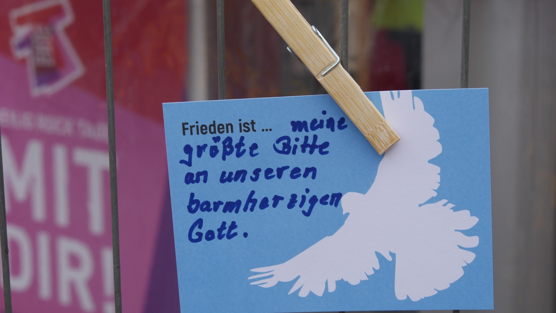 Am Zaun neben dem Infozelt hängen die Friedens-Postkarten.
