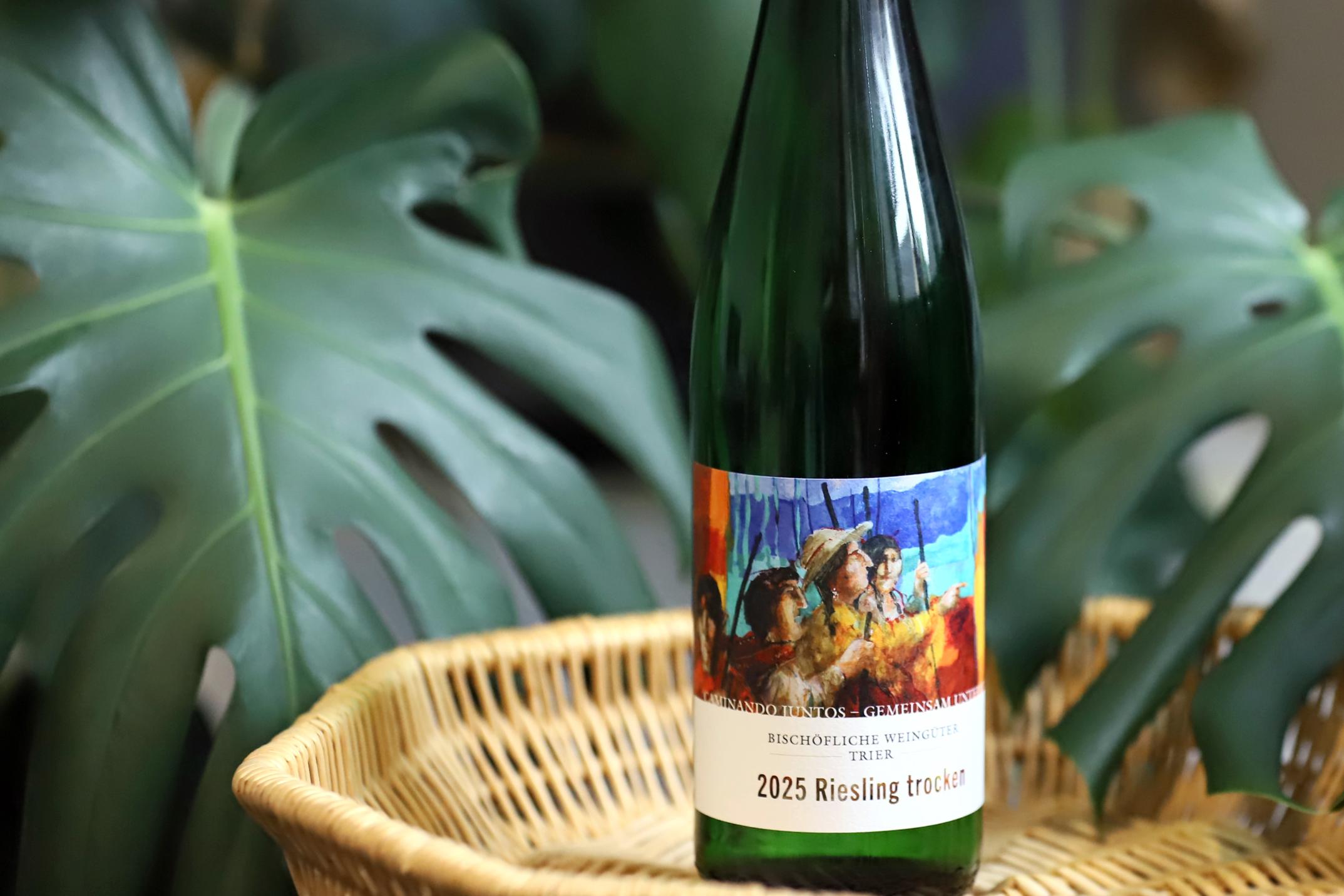 Eine Flasche Partnerschaftswein steht auf einem Tablett. Im Hintergrund eine Pflanze
