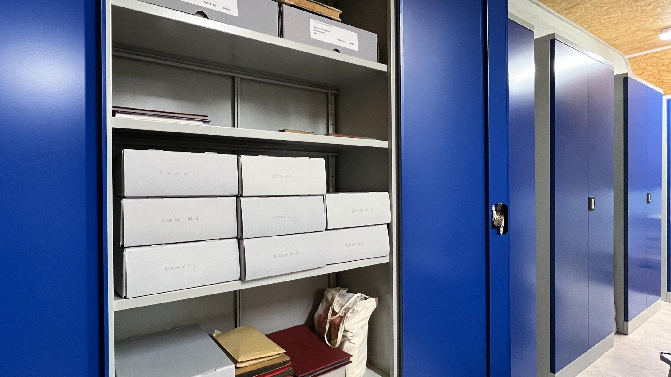 Die neuen Regale beinhalten säurefreie Archivkartons, in denen die verzeichneten Unterlagen nachhaltig gelagert werden.