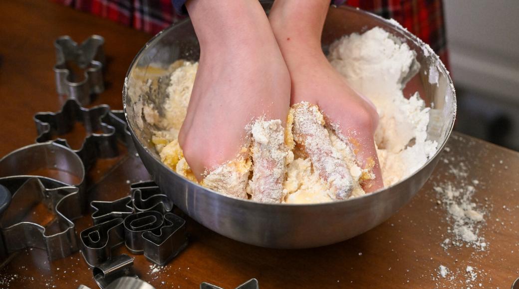 Die Hände eines Mädchens  kneten in einer Schüssel einen Teig für das  Backen von Weihnachtsplätzchen.