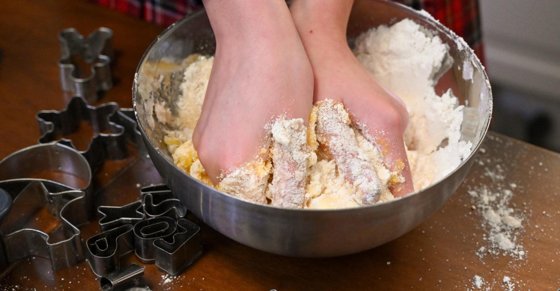 Die Hände eines Mädchens  kneten in einer Schüssel einen Teig für das  Backen von Weihnachtsplätzchen.