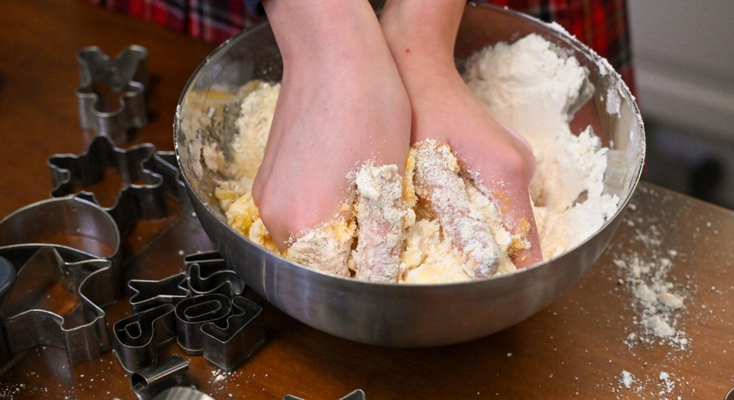 Die Hände eines Mädchens  kneten in einer Schüssel einen Teig für das  Backen von Weihnachtsplätzchen.