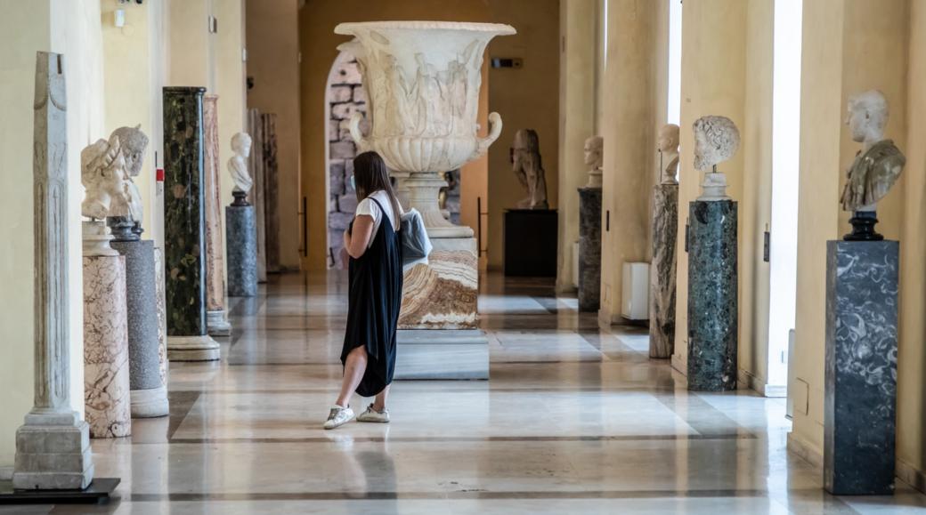 Eine Besucherin der Kapitolinischen Museen betrachtet den Kopf einer Statue.
