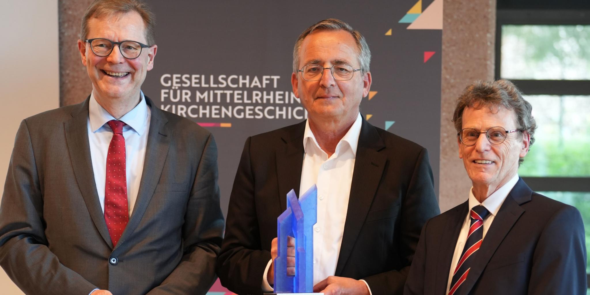 Der neue Vorsitzende Dr. Thomas Brockmann (links) und sein Vorgänger Prof. Dr. Bernhard Schneider (rechts) würdigen Prof. Dr. Wolfgang Schmid mit der Ehrengabe der Gesellschaft.