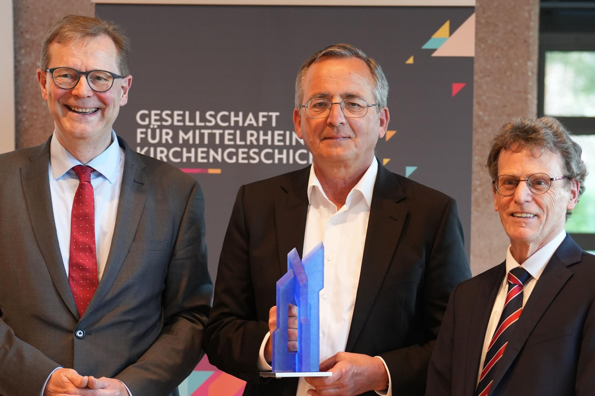 Der neue Vorsitzende Dr. Thomas Brockmann (links) und sein Vorgänger Prof. Dr. Bernhard Schneider (rechts) würdigen Prof. Dr. Wolfgang Schmid mit der Ehrengabe der Gesellschaft.