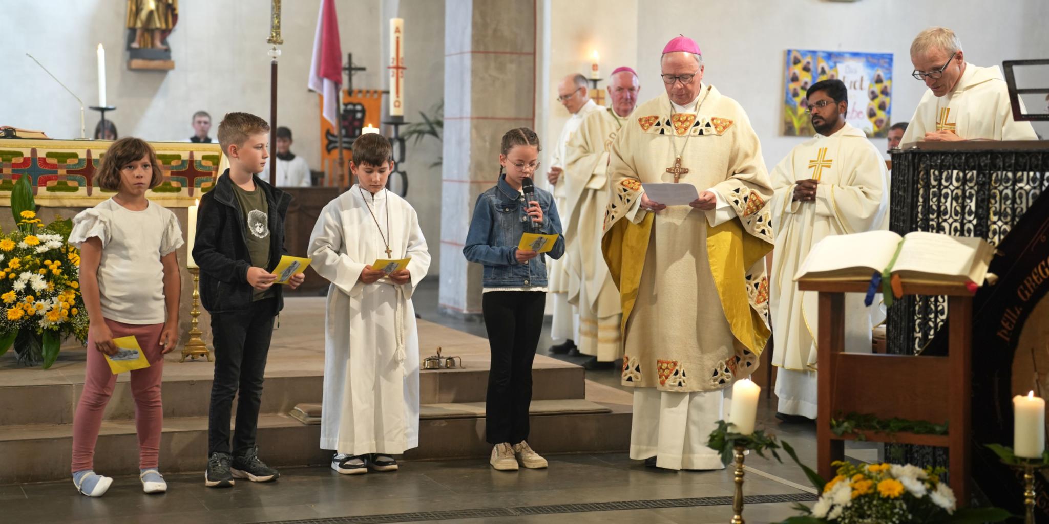 Bischof Stephan Ackermann mit Schülerinnen und Schülern der Gregor-von-Pfalzel-Grundschule, die die Fürbitten sprechen.