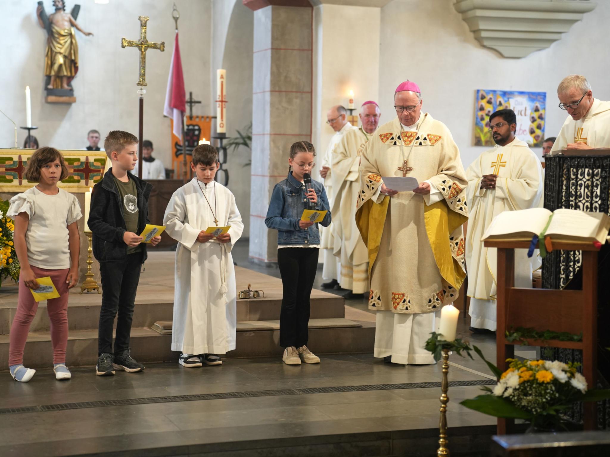 Bischof Stephan Ackermann mit Schülerinnen und Schülern der Gregor-von-Pfalzel-Grundschule, die die Fürbitten sprechen.