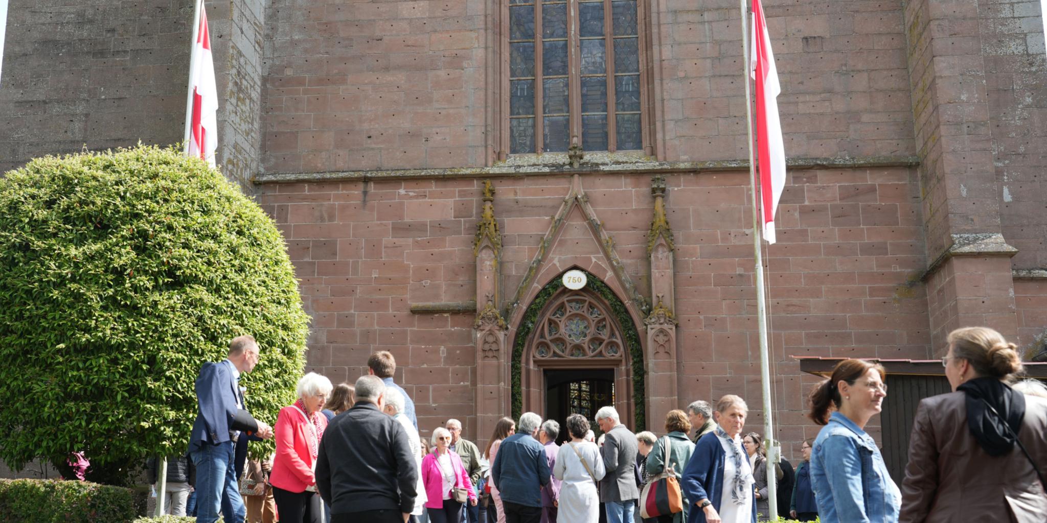 Eine Gruppe von Menschen steht vor dem Eingang der Kirche in Kyllburg