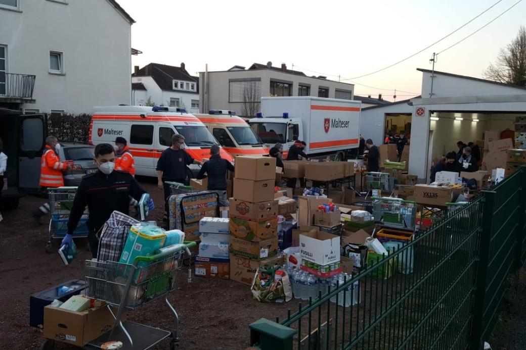 Mehrere Helfer der Malteser Trier vor einer großen LKW-Ladung an Sachspenden für die Ukraine.