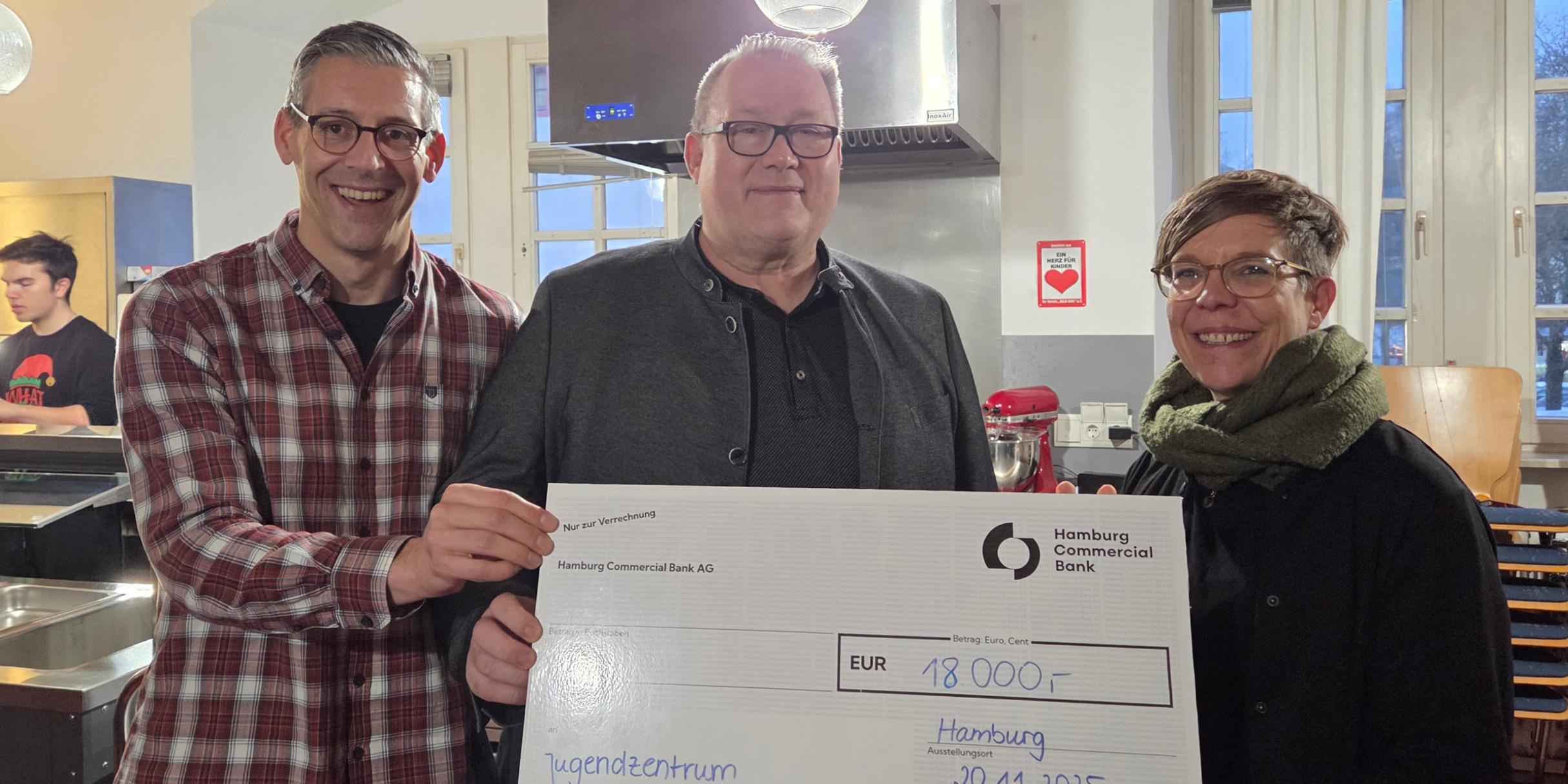 Matthias Ludwig, Leiter des Mergener Hofs, Franz-Josef Glauben und Kerstin Knopp halten einen Scheck in der Höhe von 18.000 Euro für die Miez-Box in die Kamera.