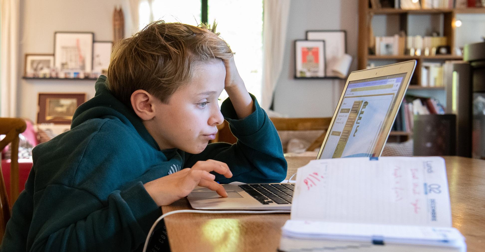 Ein Schüler arbeitet am Computer an seinen Hausaufgaben.