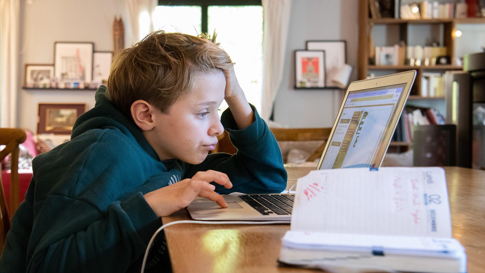 Ein Schüler arbeitet am Computer an seinen Hausaufgaben.