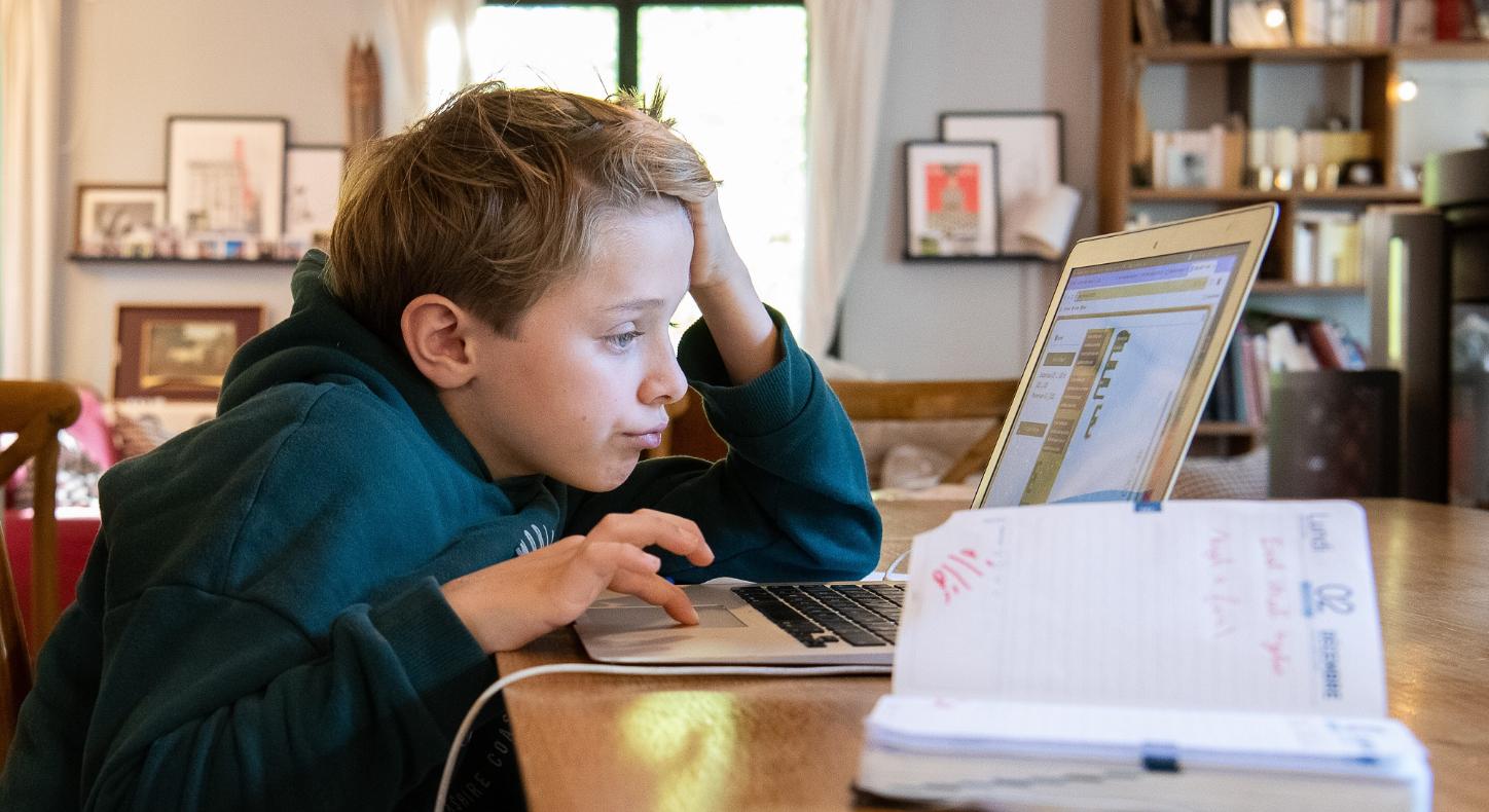 Ein Schüler arbeitet am Computer an seinen Hausaufgaben.