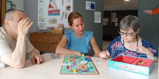 Sina Westenfelder beim Gesellschaftsspiel mit zwei Bewohnern.