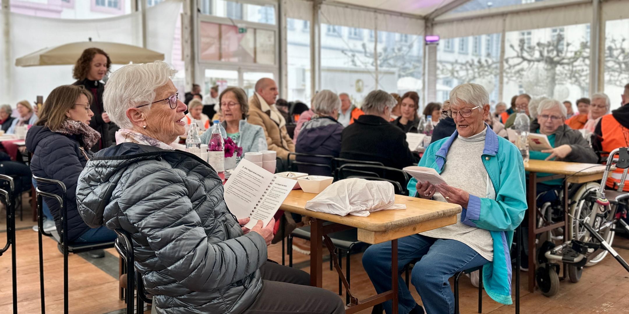 Seniorinnen und Senioren singen im Begegnungszelt