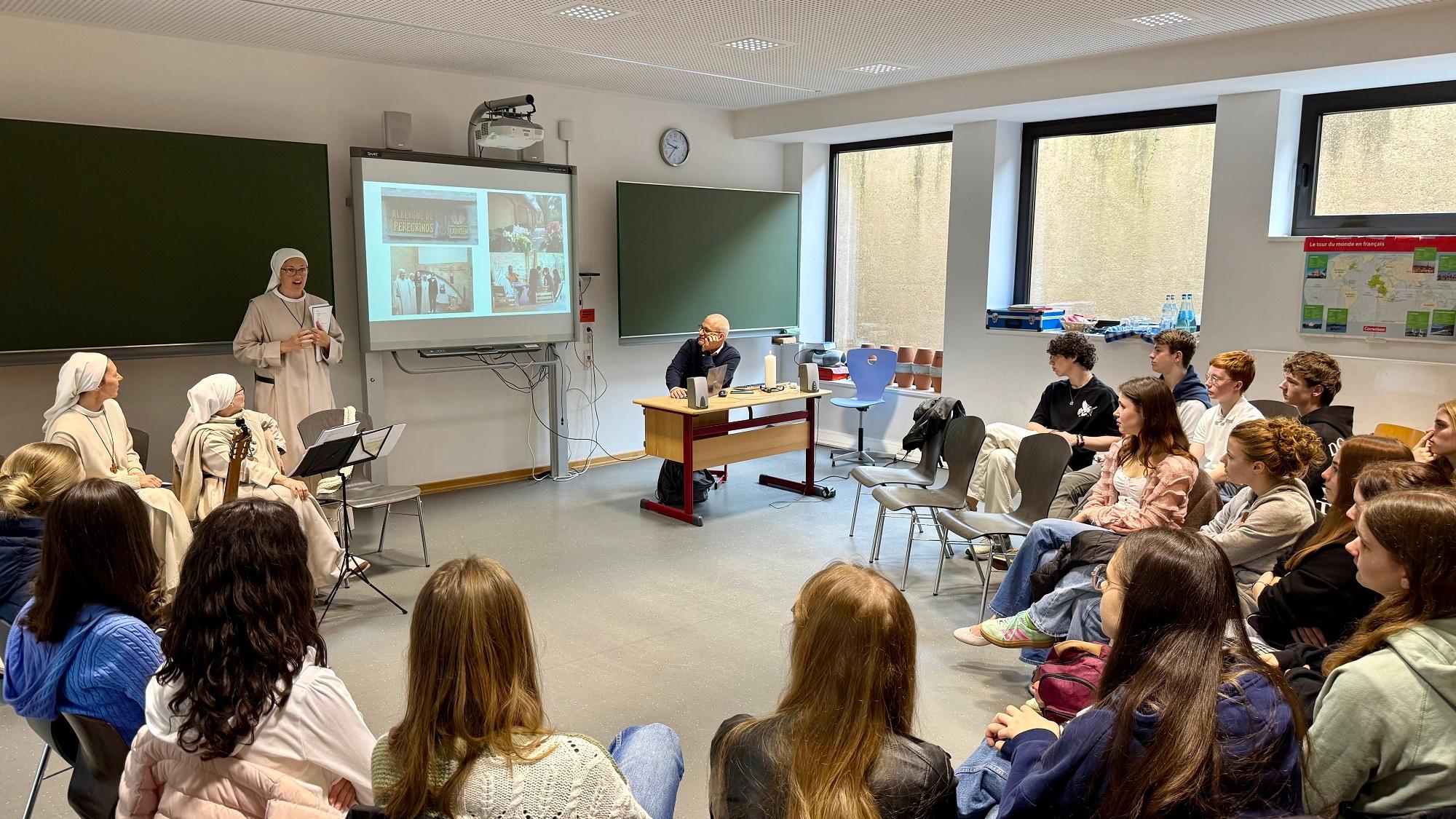 Drei spanische Ordensschwestern beim Vortrag vor einer Klasse.