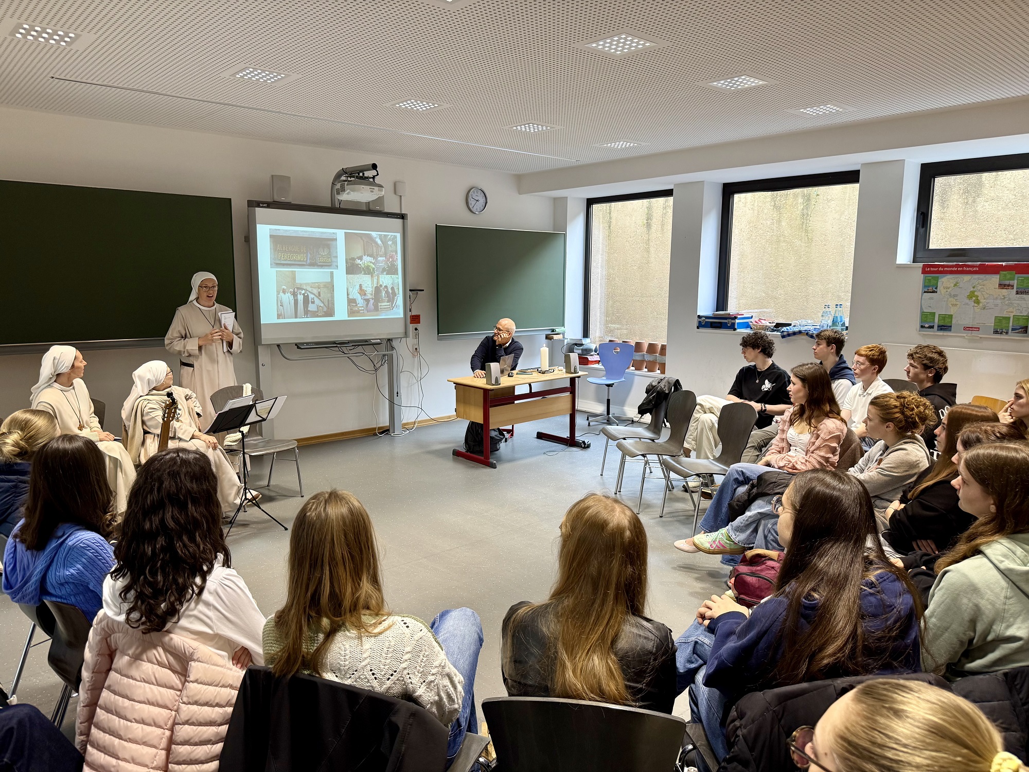 Drei spanische Ordensschwestern beim Vortrag vor einer Klasse.
