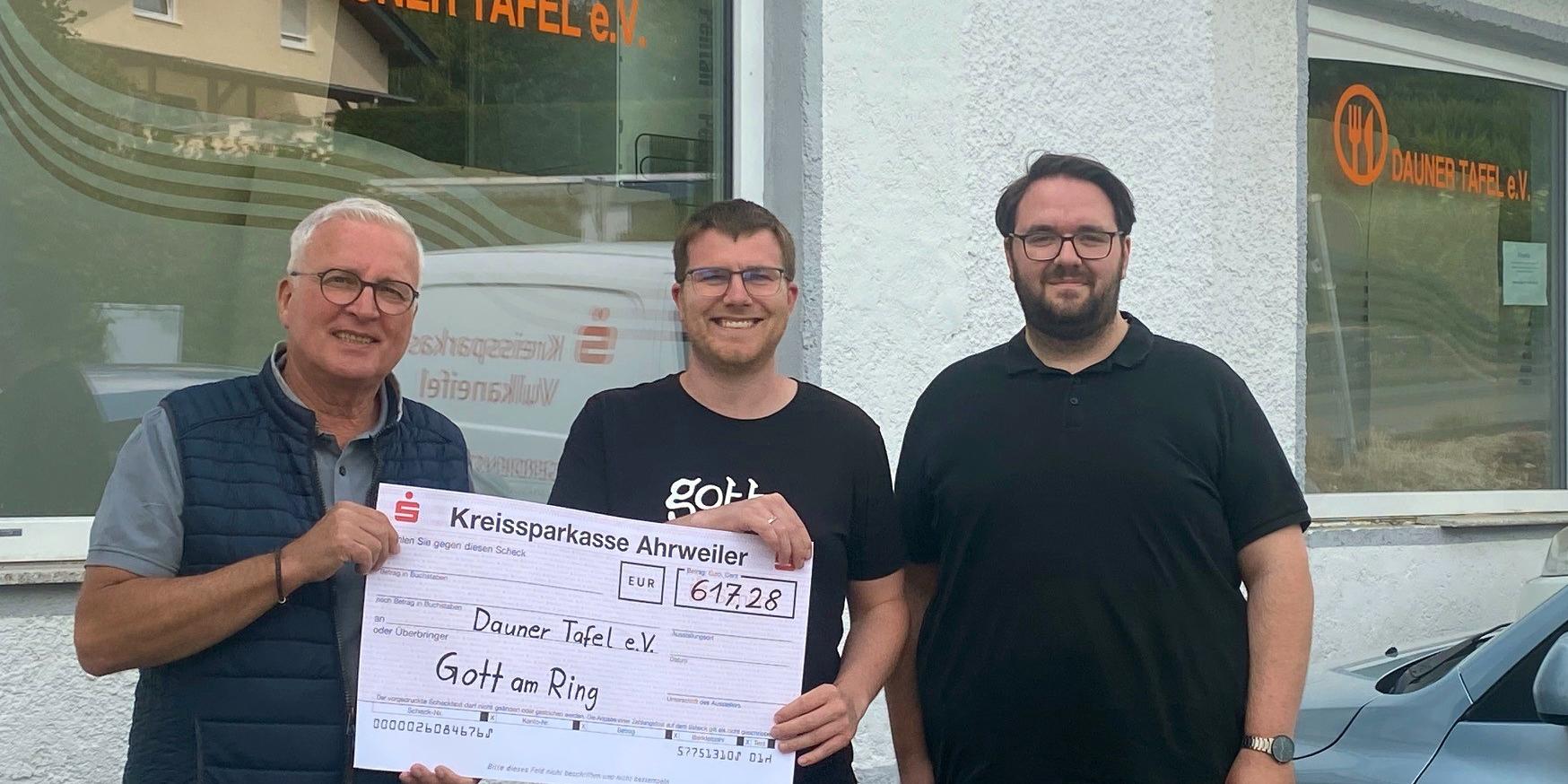 Christian Bauer (links) und Jörg Freitag (rechts) freuen sich über die Spende, die Philipp Hein vom Gott-am-Ring-Zelt der Dauner Tafel überreicht.