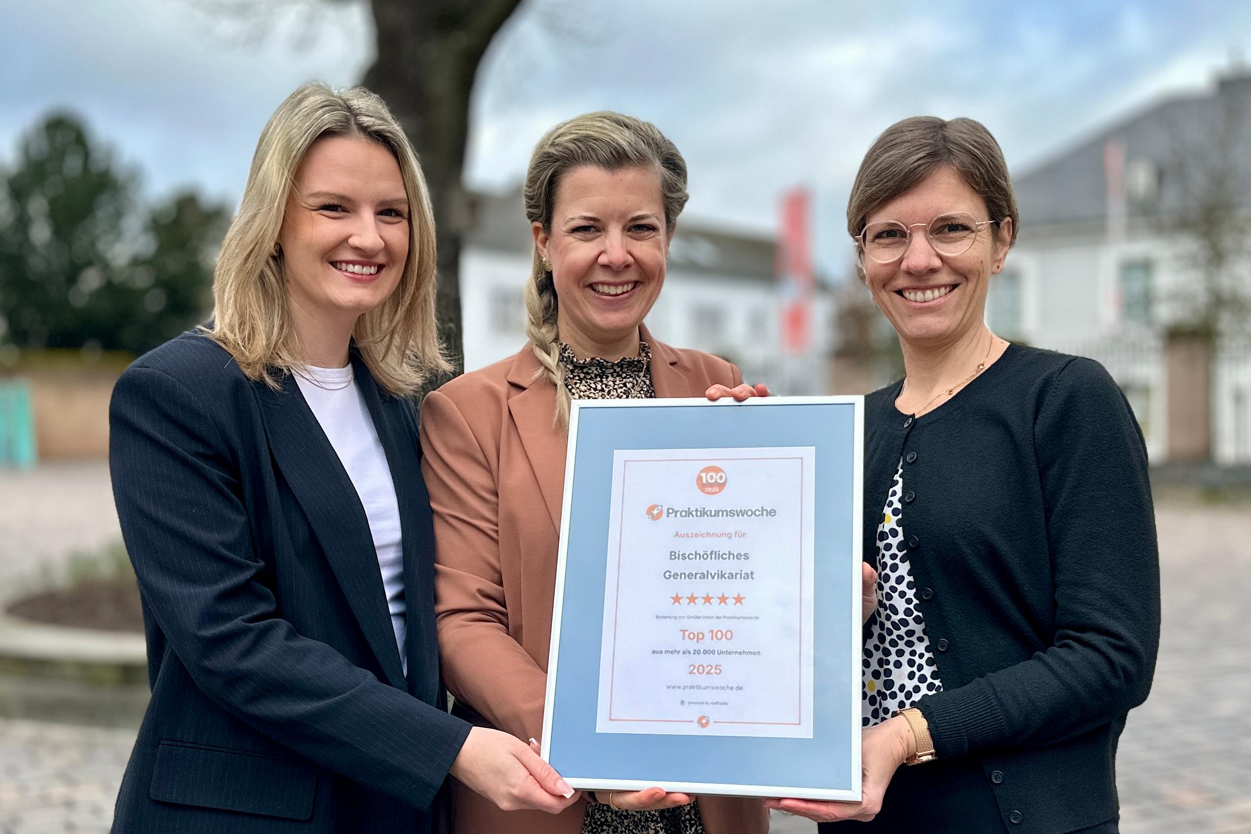 Auf dem Foto zu sehen die folgenden Personen: Svenja Buzziol (Mitte) von der IHK Trier überreicht die Auszeichnung an Lina Brendel (li.) und Frauke Backes