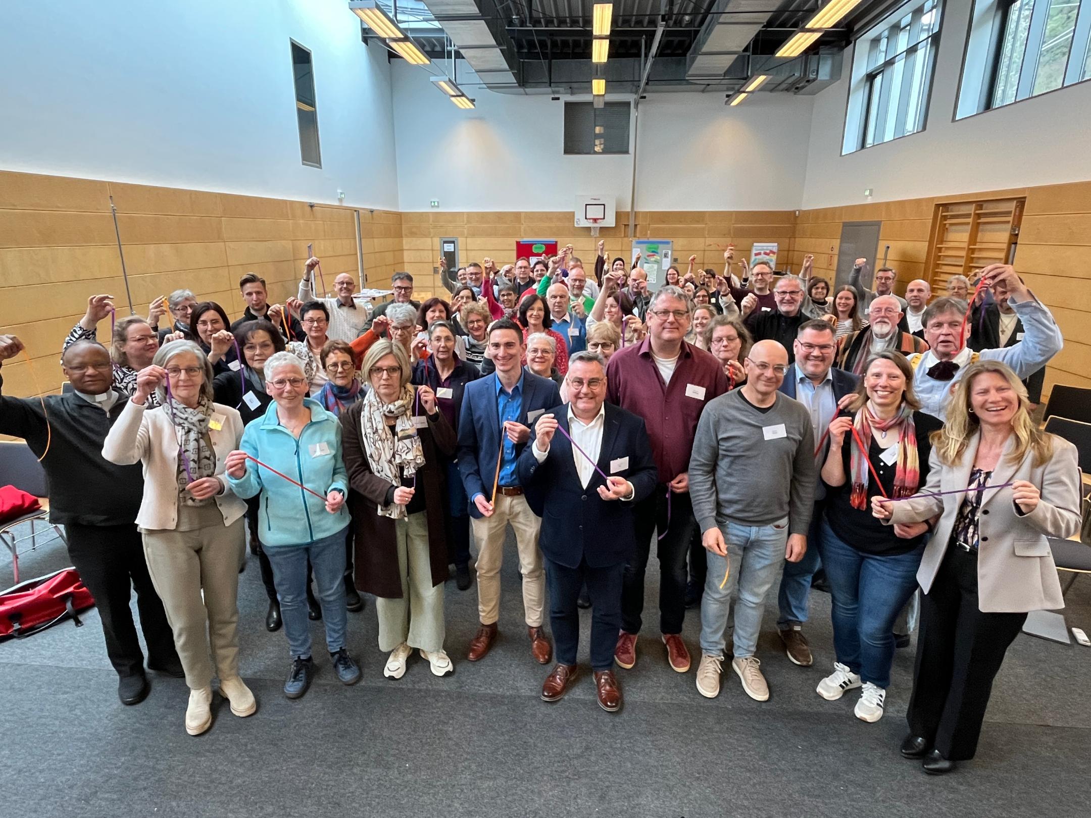 Ein Gruppenbild mit fast 80 Personen, die in die Kamera lächeln.