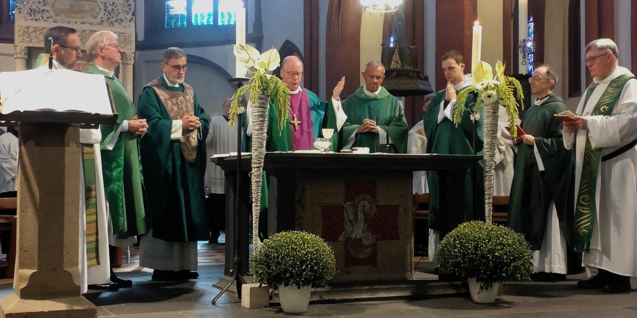 Geistliche stehen versammelt um einen Altar,