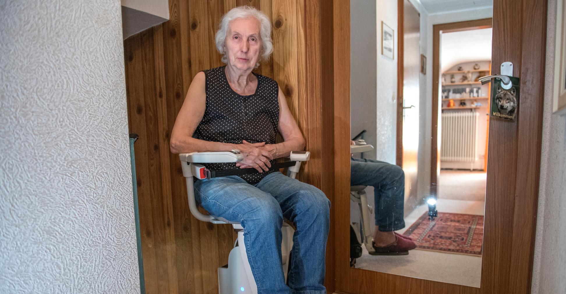Eine Frau sitzt auf einem Treppenlifter