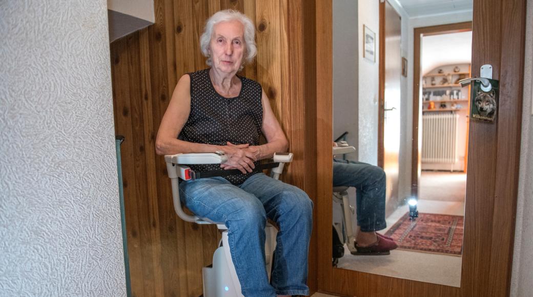 Eine Frau sitzt auf einem Treppenlifter