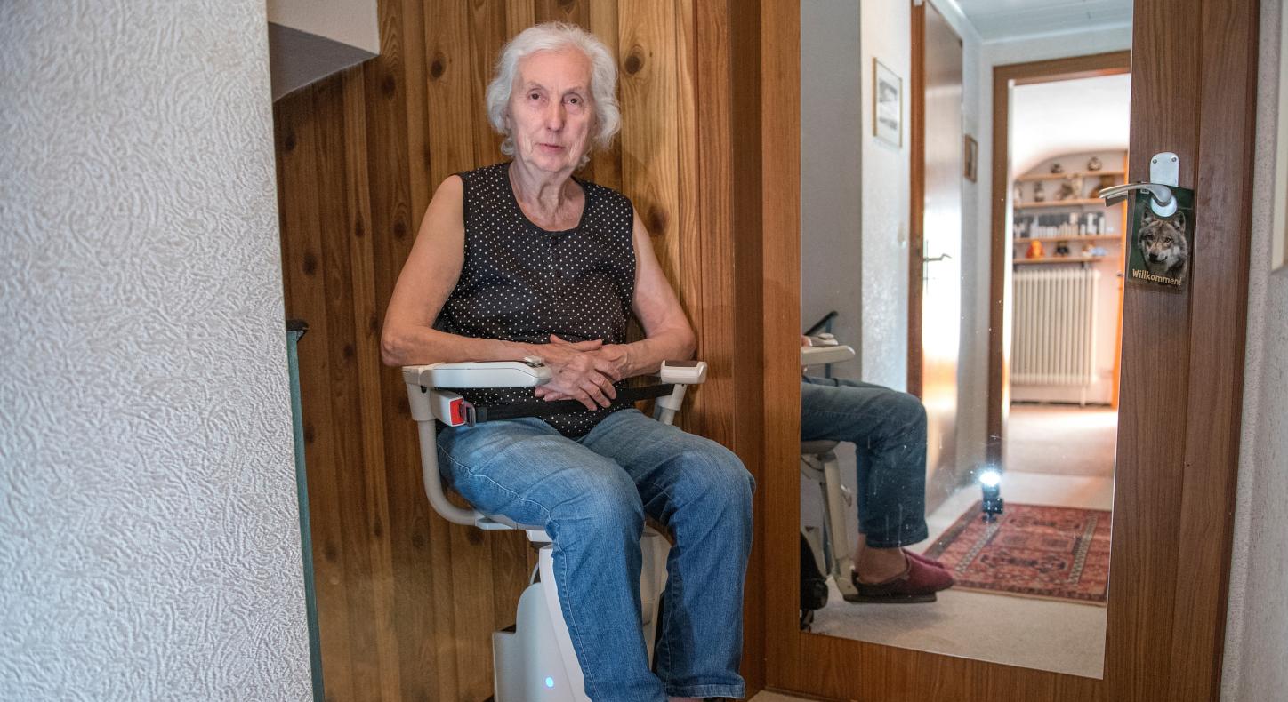 Eine Frau sitzt auf einem Treppenlifter