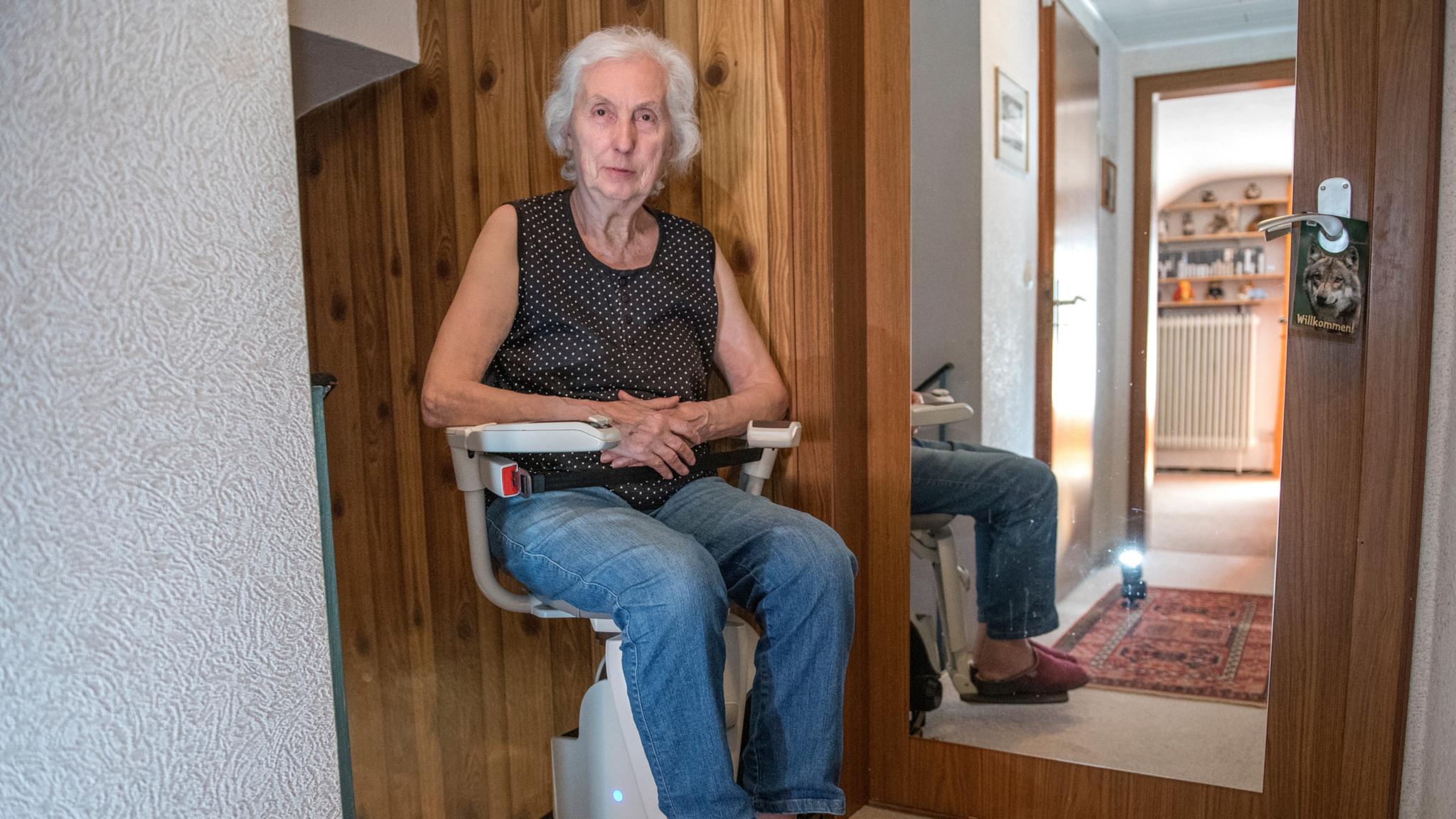 Eine Frau sitzt auf einem Treppenlifter