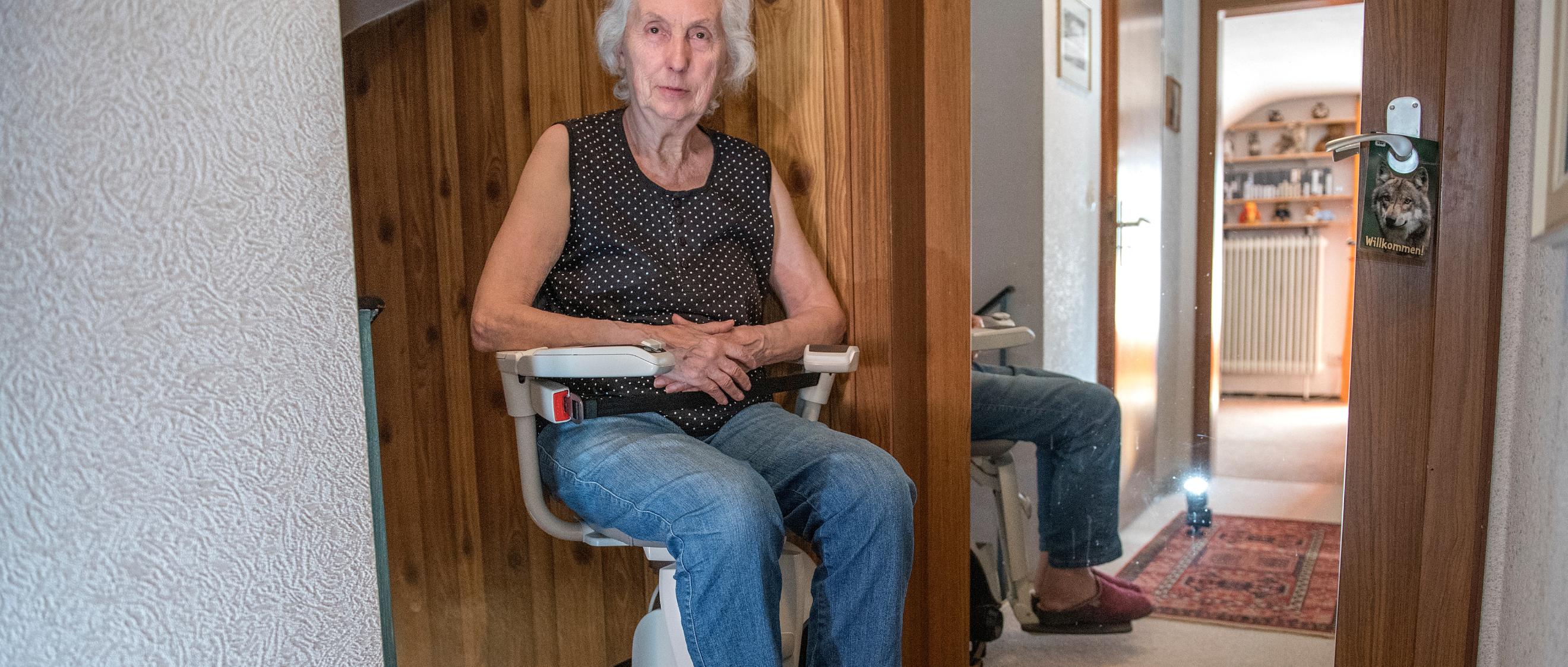 Eine Frau sitzt auf einem Treppenlifter