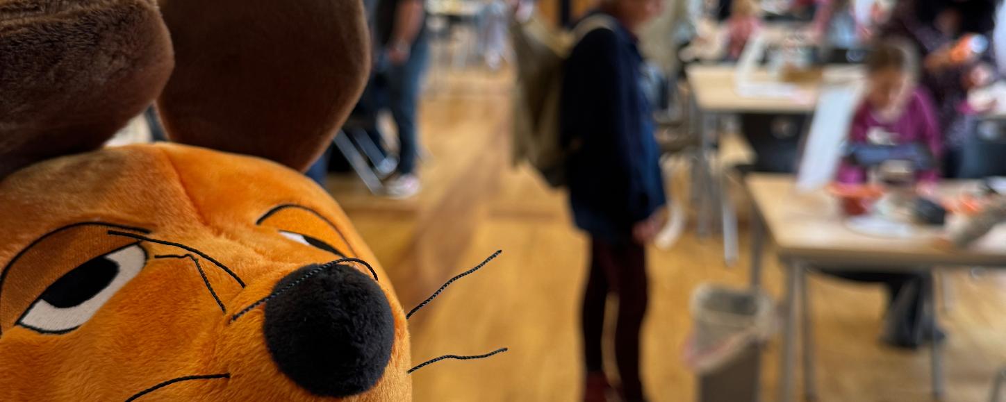 Die Maus ist zu sehen und im Hintergrund Menschen