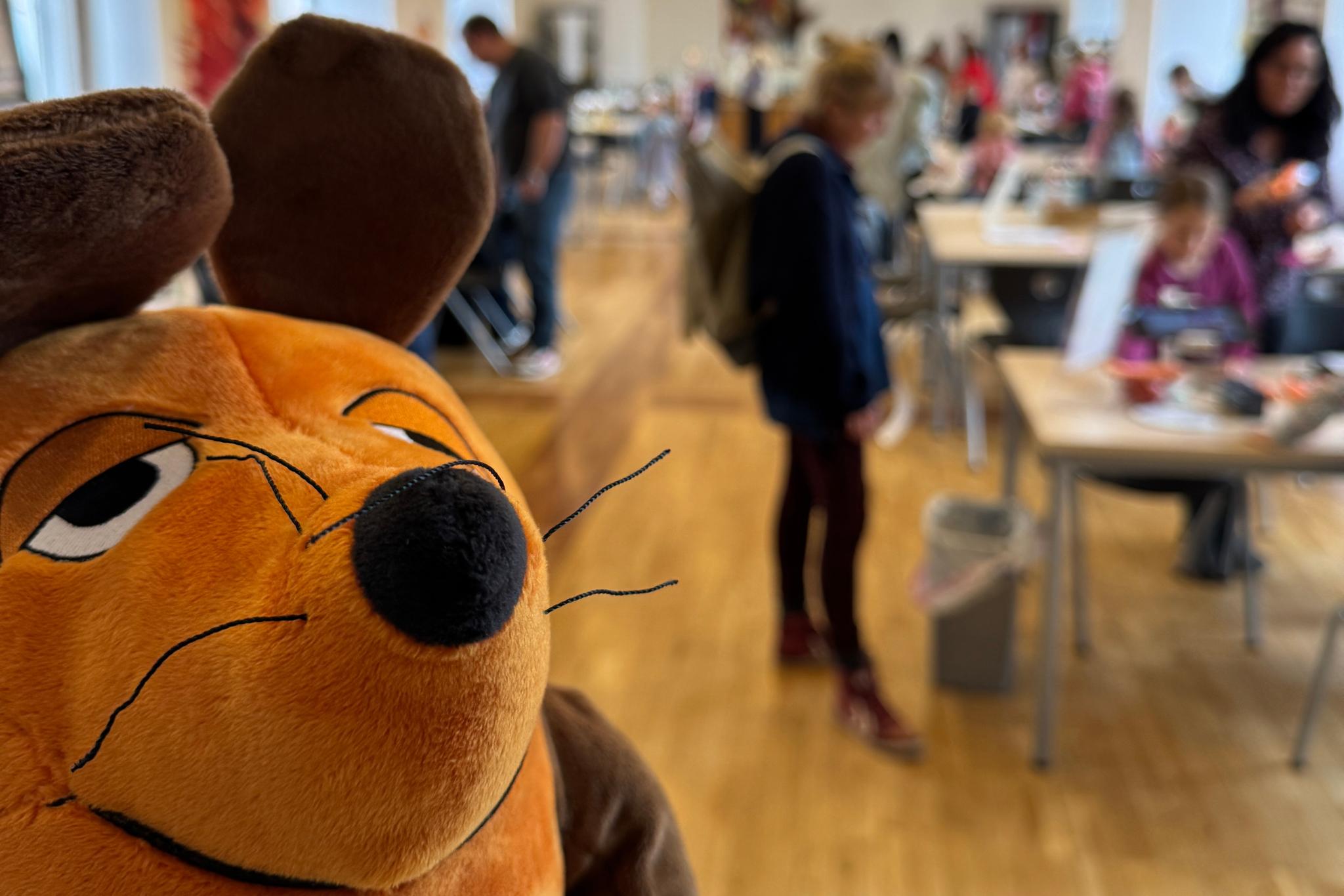 Die Maus ist zu sehen und im Hintergrund Menschen