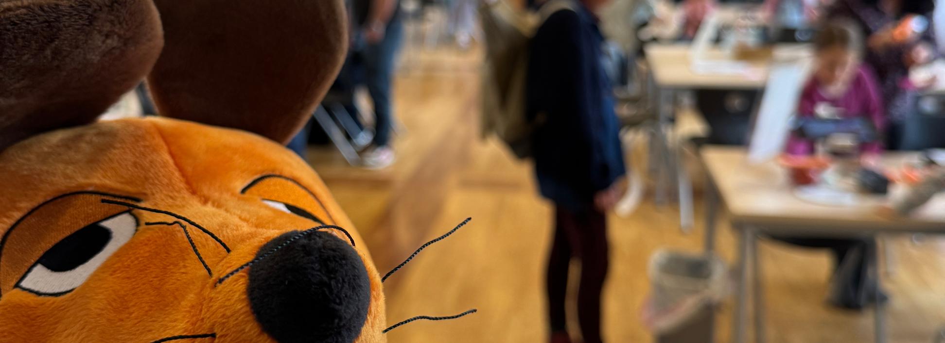 Die Maus ist zu sehen und im Hintergrund Menschen