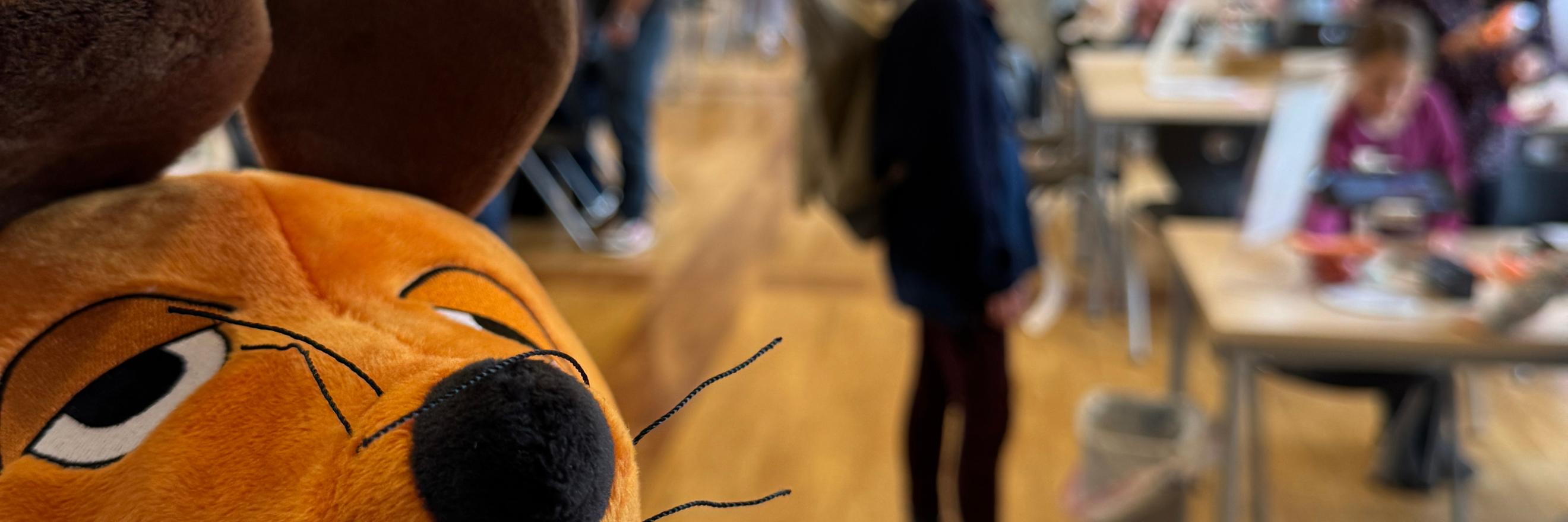 Die Maus ist zu sehen und im Hintergrund Menschen