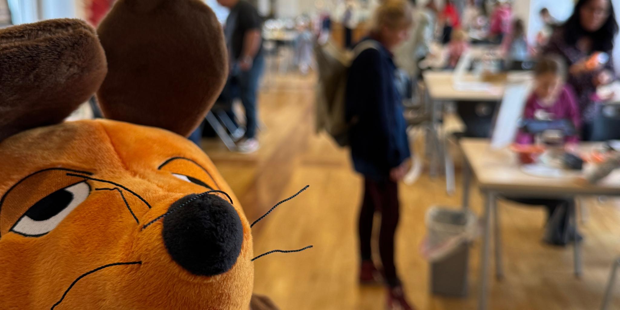 Die Maus ist zu sehen und im Hintergrund Menschen