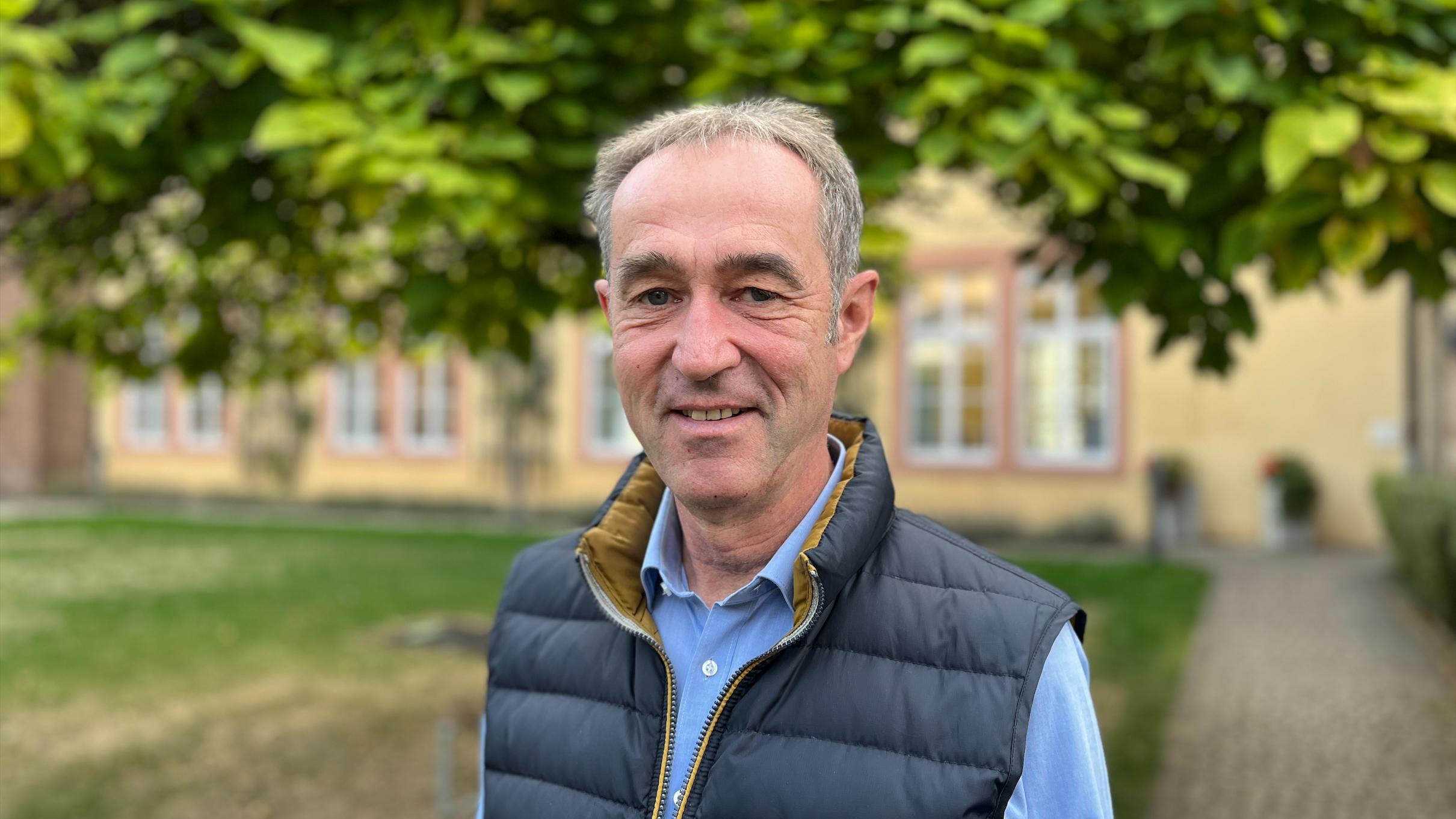 Prof. Dr. Klaus Vellguth, Inhaber des Lehrstuhls für Pastoraltheologie mit Homiletik vor einem Baum stehend