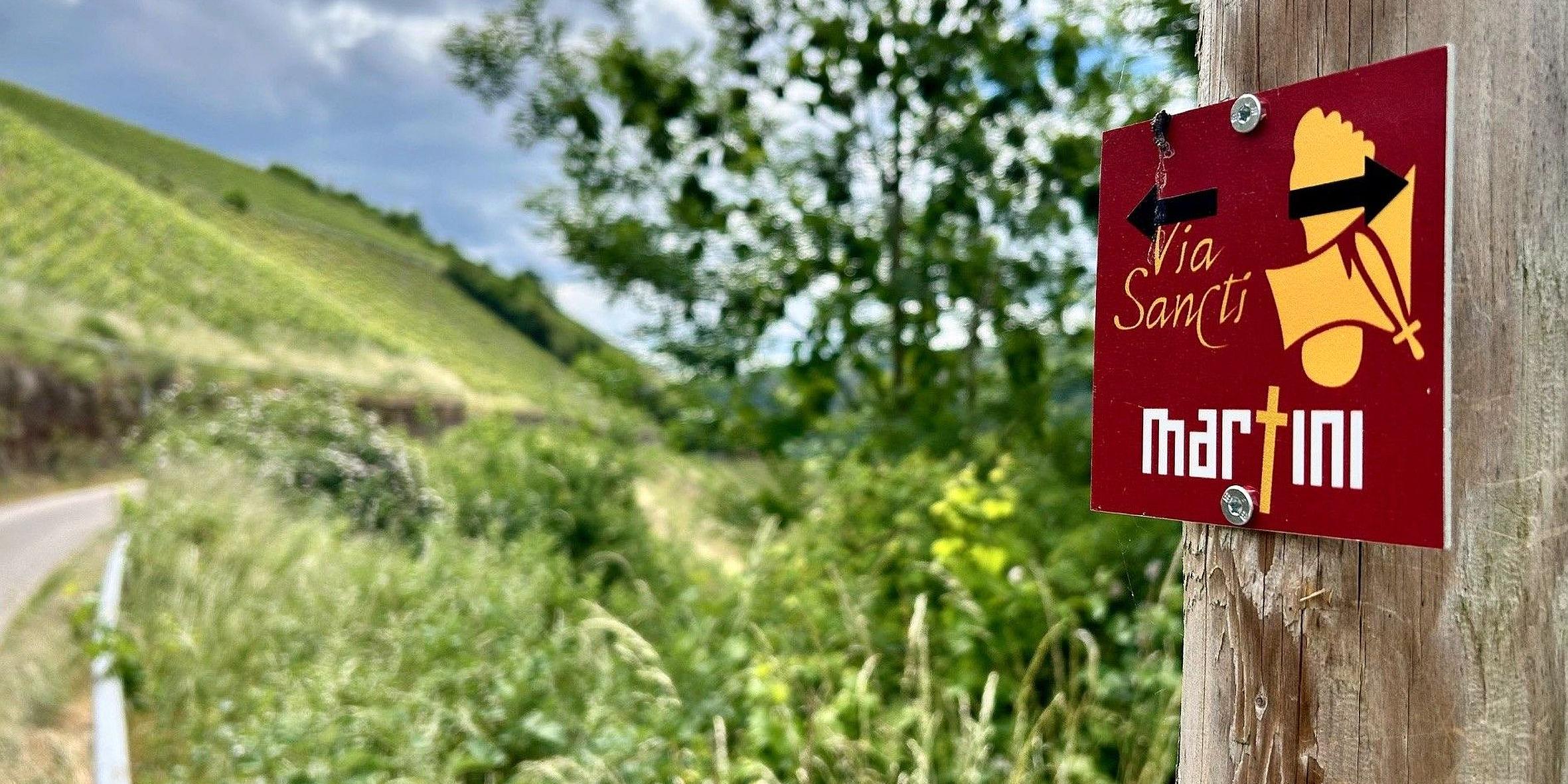Kleine rote Hinweisschilder weisen Pilger und Spaziergänger auf die Streckenführung des Europäischen Martinswegs hin.