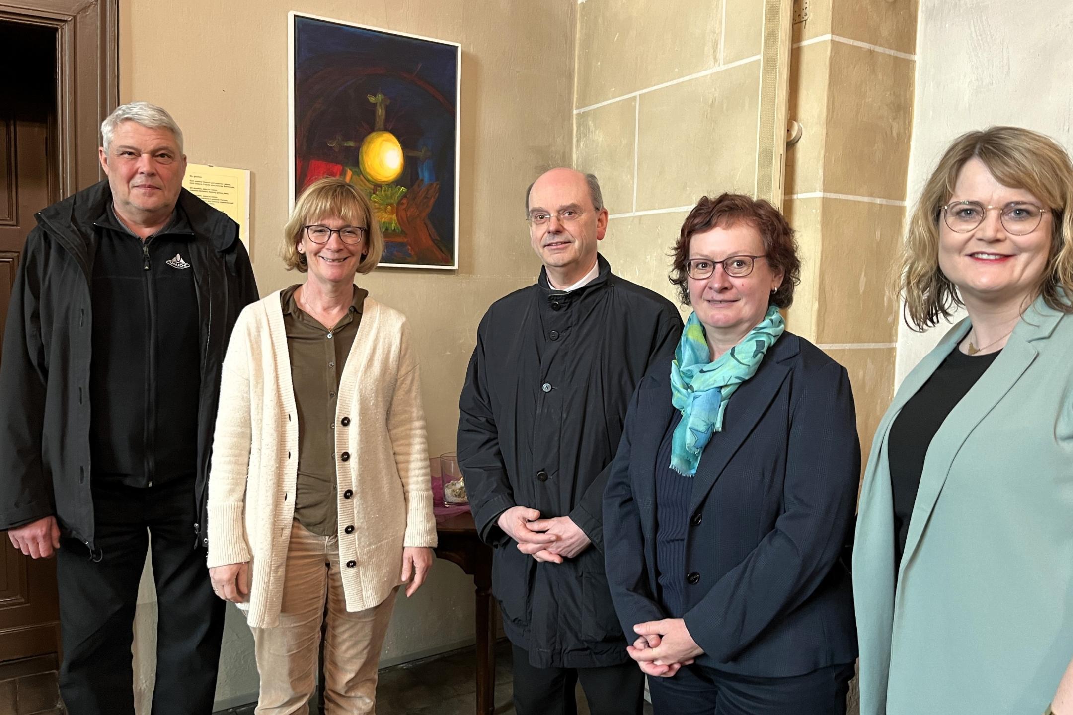 Der Trierer Weihbischof Robert Brahm (Mitte) besuchte gemeinsam mit seiner Referentin Katja Neff (Zweite v. rechts) und Dekan des Pastoralen Raums Eric Condé (links) die Klinikseelsorgerinnen Marion Jensen (Zweite v. links) und Melanie Kammerer (rechts). In der Kirche der Rhein-Mosel-Fachklinik Andernach betrachtete die Gruppe unter anderem ein Gemälde, das von einer Patientin hergestellt wurde.