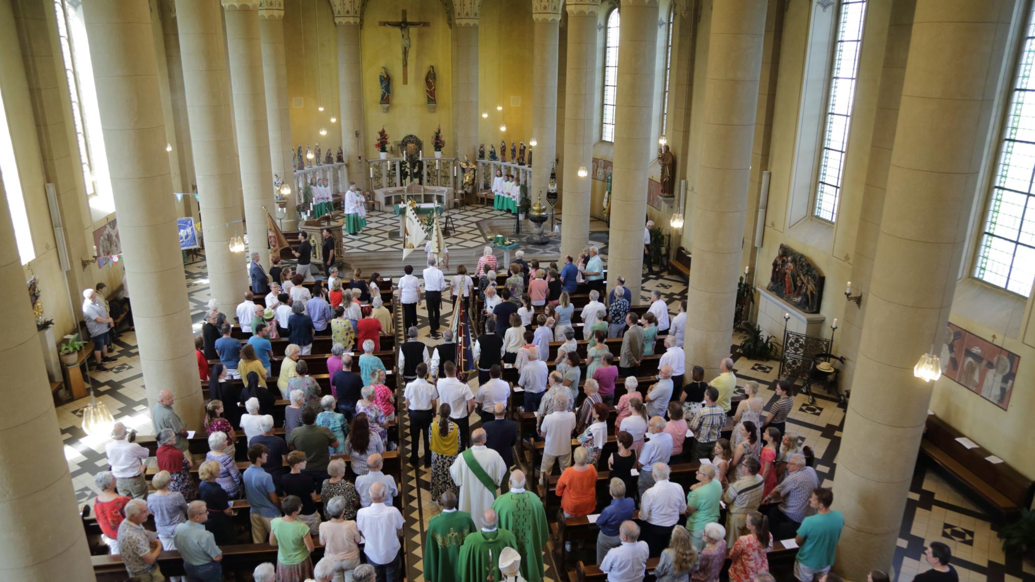 In einer Kirche sind während eines Gottesdienstes alle Plätze von Menschen besetzt
